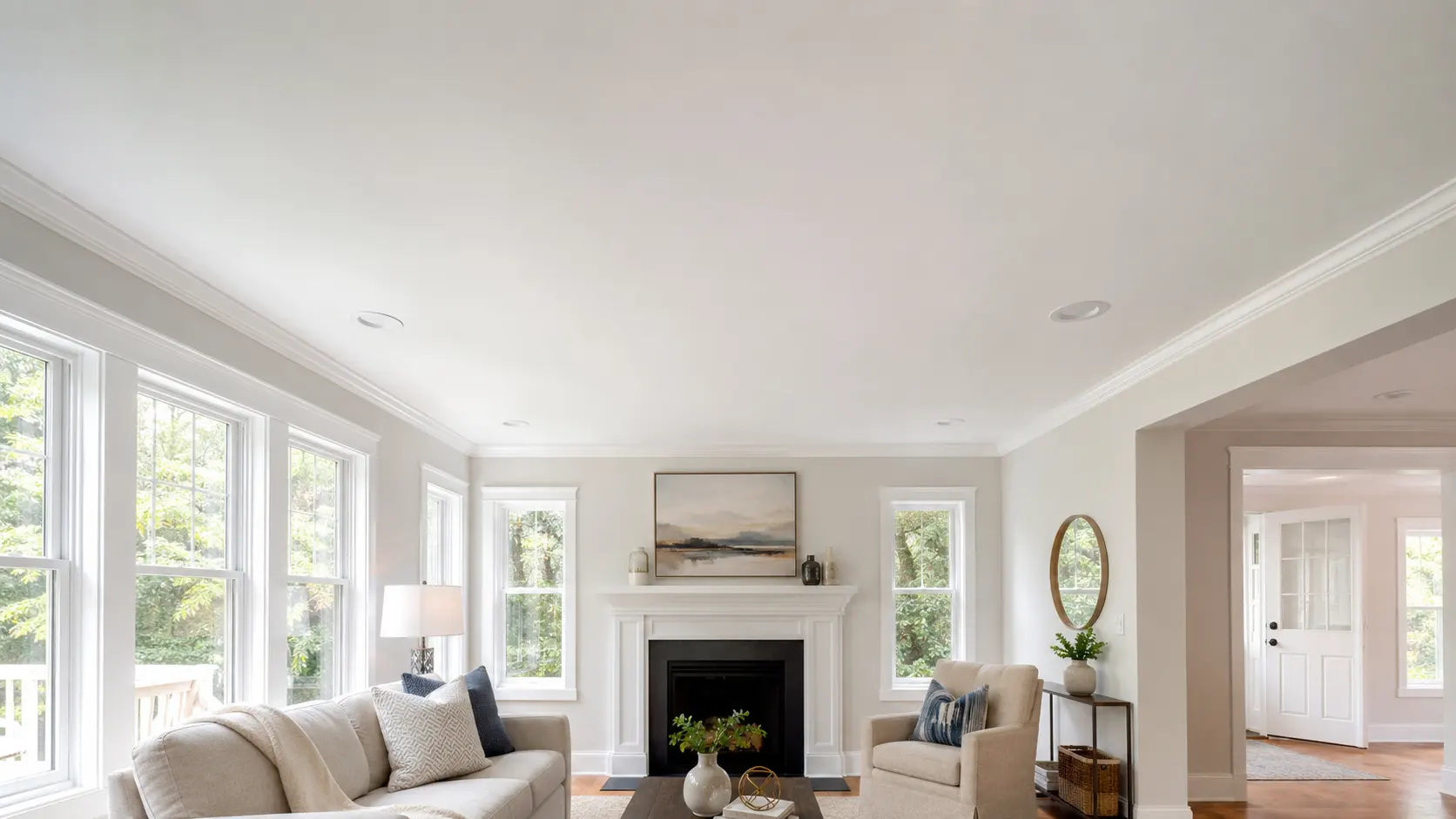 A bright living room with a perfectly repaired and freshly painted ceiling showing no signs of previous water damage.